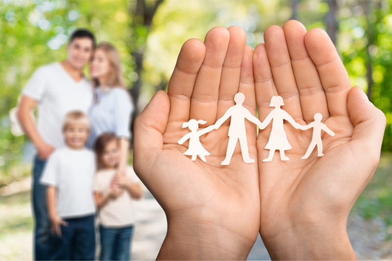 hands-with-family-paper-people-park-background